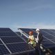 Businessman and worker near solar energy batteries. Business client showing photovoltaic detail to foreman. Two men making deal.